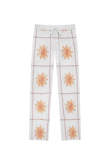 Güneş motifi işlemeli beyaz dökümlü pantolon