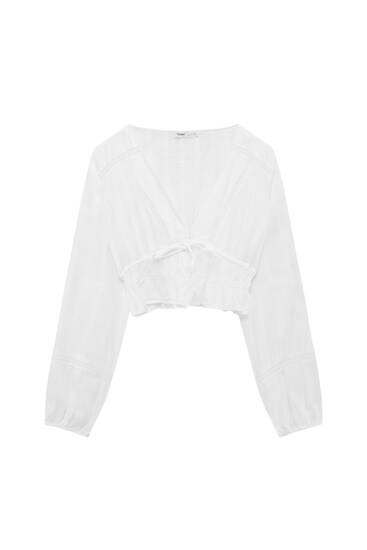 Biała bluzka oversize z koronkowym wykończeniem