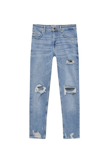 Jeans skinny fit rotos bajo deshilachado