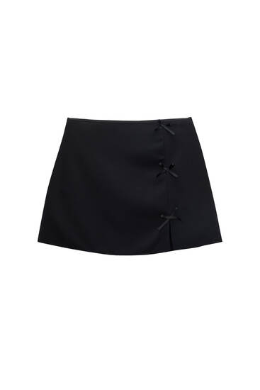 Mini skirt with a slit and bow details