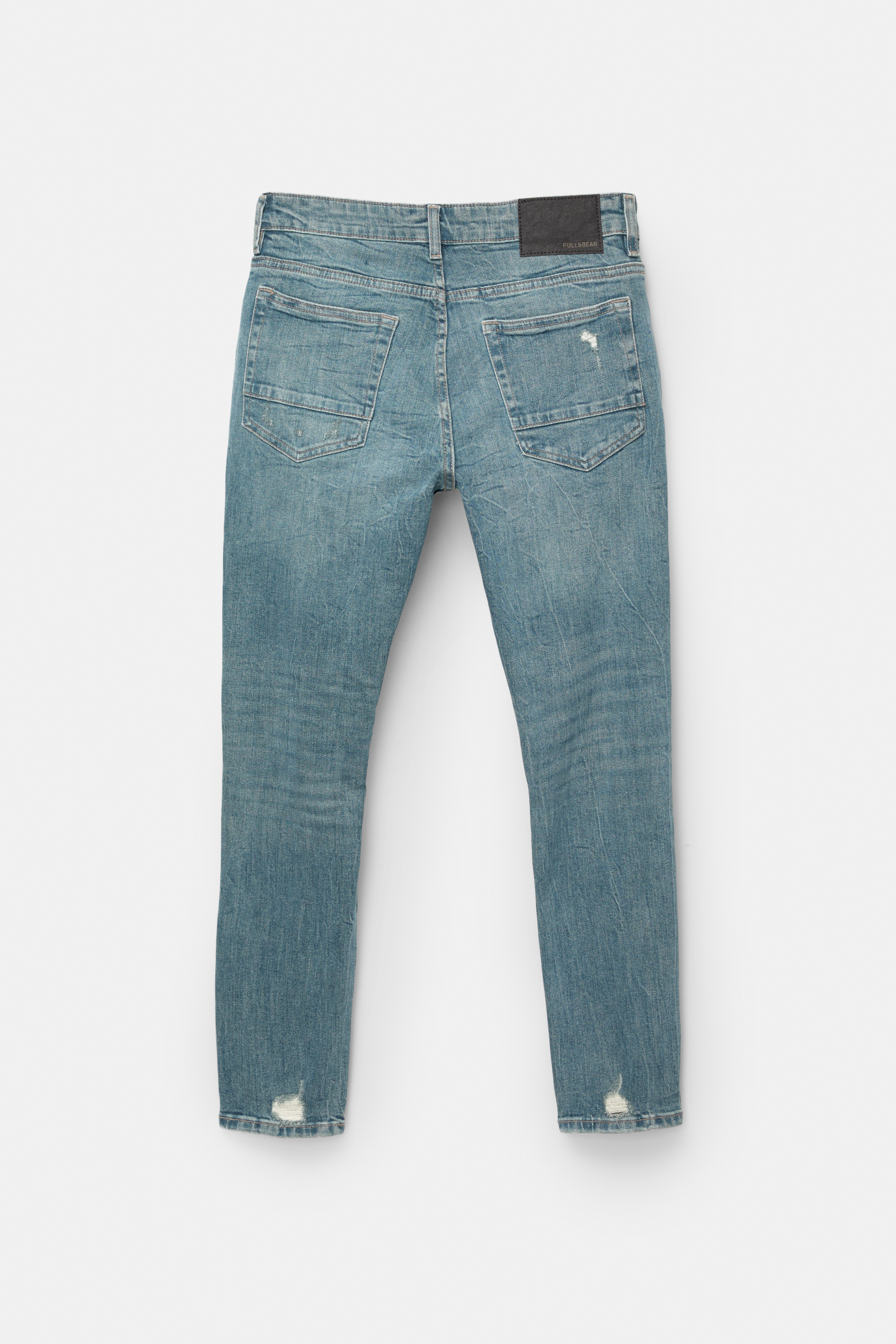 Cieši pieguļoši džinsi ar plēsumiem