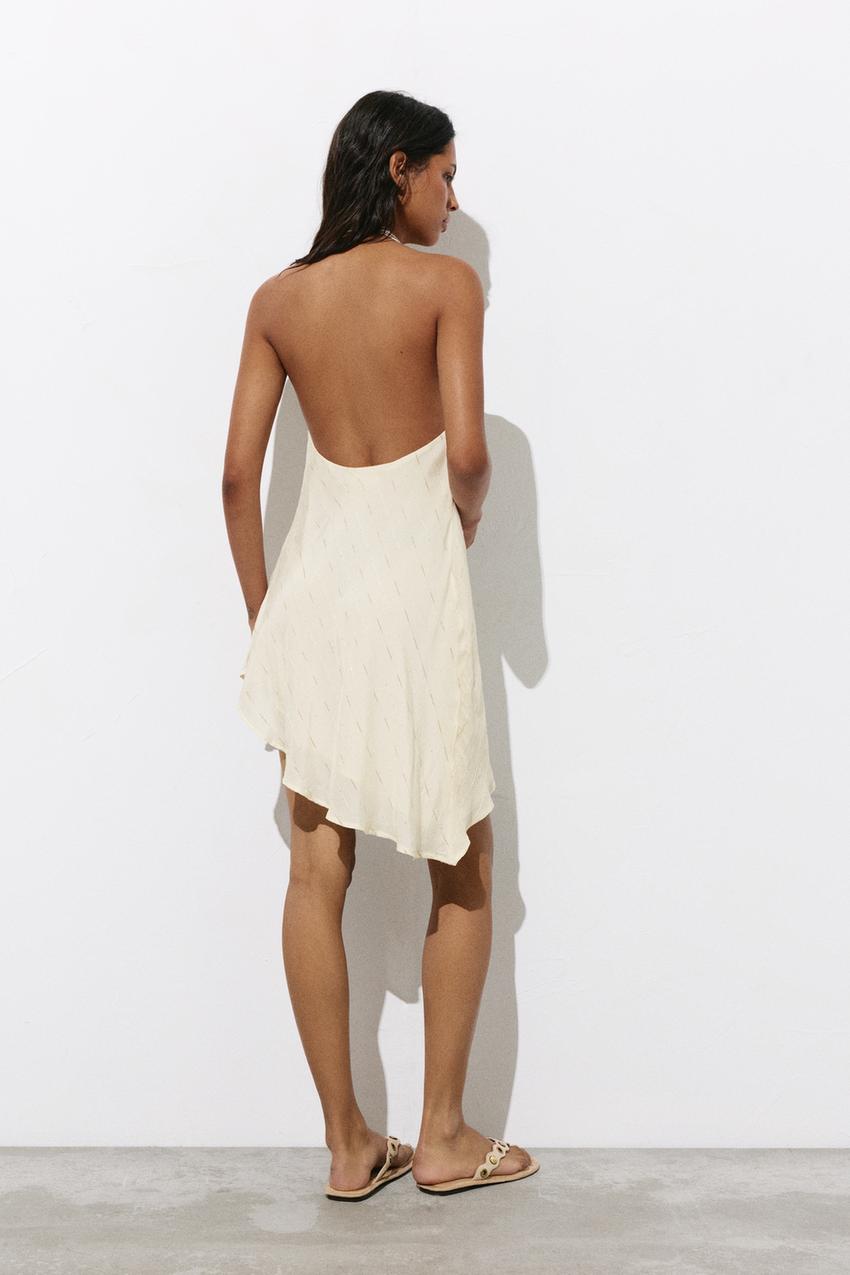 Short asymmetric ecru dress set with a halter neck and open back.
