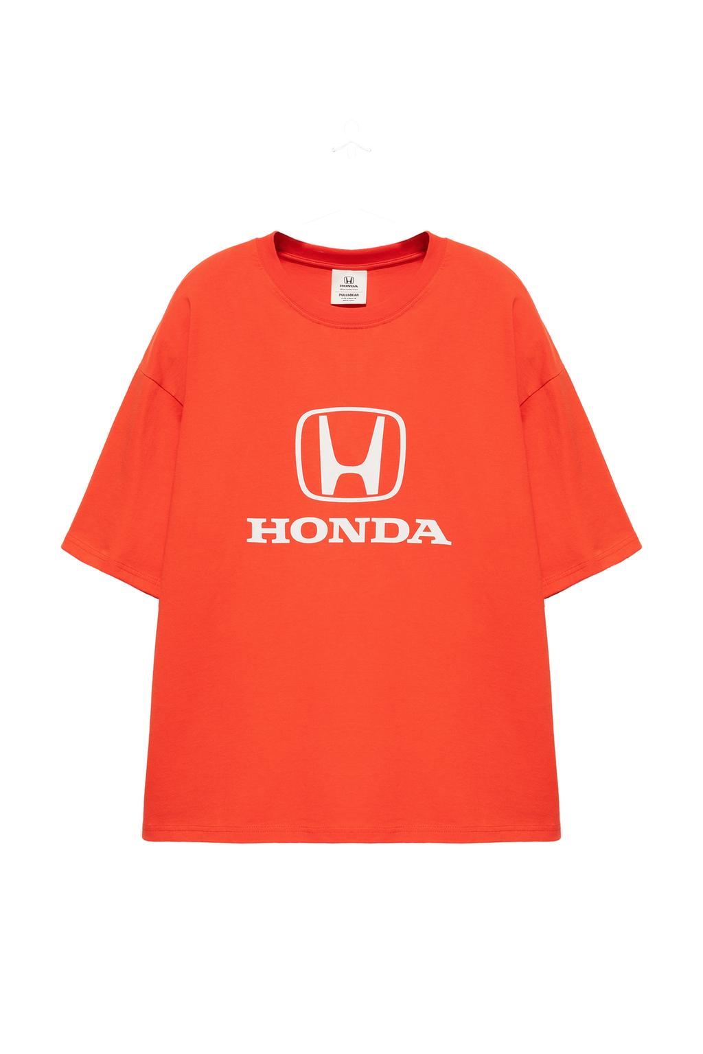 Göğüs kısmında beyaz logo baskısı ve 'HONDA' yazısı bulunan, kısa kollu, bisiklet yaka, kırmızı tişörtün önden görünümü.