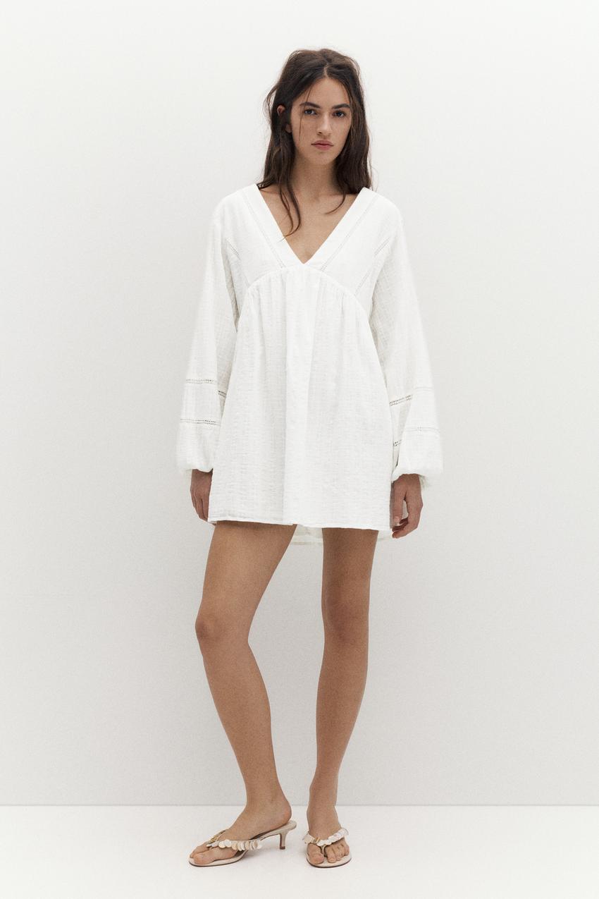 Short white dress set with long puff sleeves, a V-neck, and lace detailing.